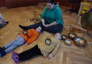 kobieta, przedszkolaki z misami tybetańskimi na brzuchu