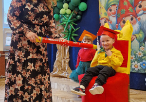 przedszkolak na przystrojonym krześle, pasowany na przeszkolaka