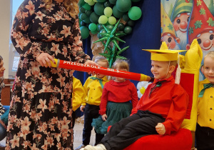 przedszkolak na przystrojonym krześle, pasowany na przeszkolaka