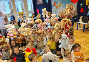 grupa przedszkolaków, kobieta z misiami w rękach