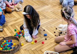 pzredszkolaki, dziewczynki w rękawicach kuchennych na ręce, koszyki, klocki, kasztany