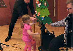 muzyk, dziewczynka przy choince