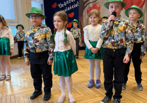 przedszkolaki w strojach, kapeluszach, tło-baner dekoracyjny z tekstem