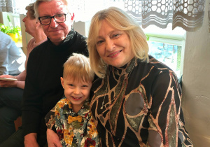 przedszkolak z przytulającą go babcią, dziadek