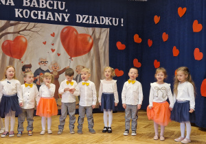 przedszkolaki ustawione e w rzędzie, w tle baner z postaciami i napisem