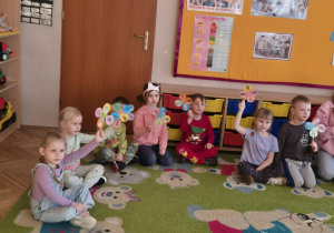 sala przedszkolna, przedszkolaki z kwiatkami w rękach