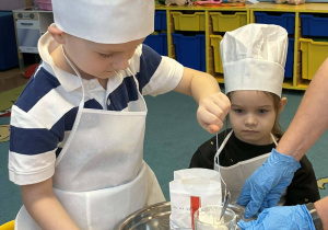 przedszkolaki w czapkach kucharskim, wsypywanie mąki do miski