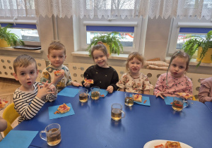 sala przedszkolna, przedszkolaki jedzące pizzę