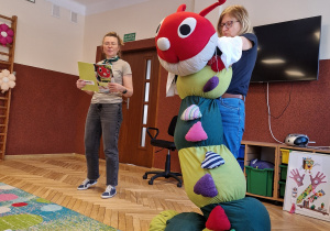 2 kobiety, duża maskotka-gąsienica