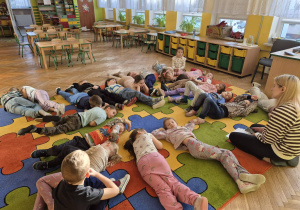 sala przedszkolna, przedszkolaki leżące na dywanie