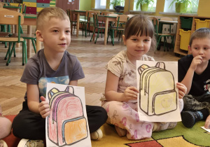 przedszkolaki z obrazkami plecaków w rękach