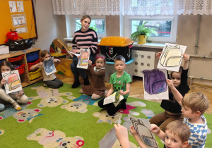 przedszkolaki z obrazkami plecaków w rękach, p. psycholog