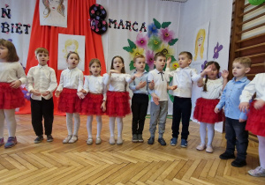 grupa przedszkolaków, w tle dekoracja z okazji 8 marca