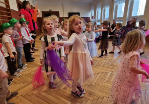 chłopcy w zielonych kapeluszach, dziewczynki tańczące z chustkami