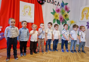 grupa chłopców na tle dekoracji z okazji 8 marca