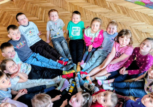 grupa przedszkolaków n dywanie w kole w kolorowych skarpetkach