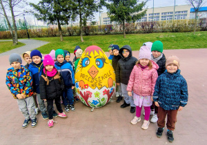 grupa przedszkolaków, duże ozdobione wielkanocne jajo
