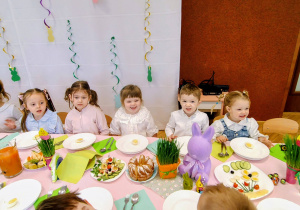 grupka przedszkolaków, stół z wielkanocnymi potrawami