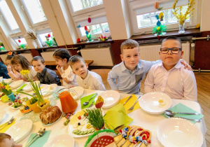 grupka przedszkolaków, stół z wielkanocnymi potrawami