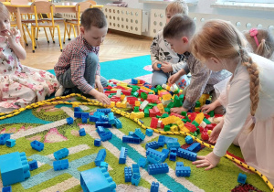 przedszkolaki, sala przedszkolna, kolorowe klocki na dywanie