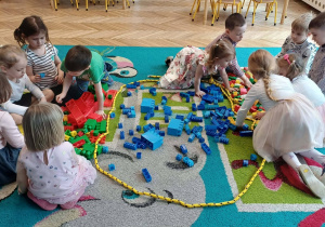 przedszkolaki, sala przedszkolna, kolorowe klocki na dywanie