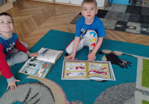 przedszkolaki siedzące na dywanie, książki