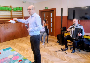 sala przedszkolna mężczyzna z mikrofonem, akordeonista, skrzypaczka