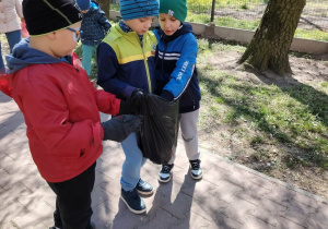przedszkolaki na dworze, z workiem na śmieci w rękach