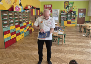 sala przedszkolna, przedszkolaki, mężczyzna z flagą europejską w ręku