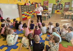 sala przedszkolna, przedszkolaki, mężczyzna z flagą Polski w ręku