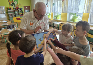 sala przedszkolna, przedszkolaki, mężczyzna z mapą w ręku