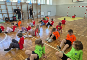 szkolna sala gimnastyczna, przedszkolaki wykonujący ćwiczenia