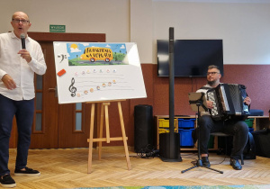 akordeonista, mężczyzna obok tablicy z nutkami