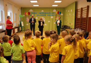 grupa przedszkolaków, osoby dorosłe na tle dekoracji na Dzień Przedszkolaka