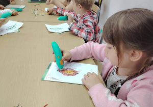przedszkolaki przy stoliku, wykonywanie listków za pomocą długopisów 3D