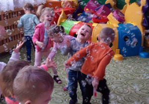 dzieci bawiące się wśród baniek mydlanych