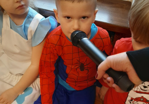Chłopiec odpowiada do mikrofonu.