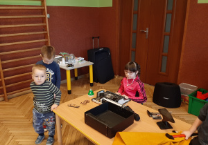 dziewczynka przy maszynie do pisania i dwóch chłopców