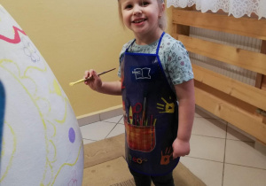 Zuzia maluje jajko.