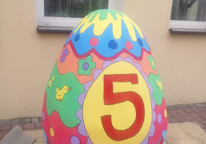Pomalowane jajko stoi przez przedszkolem.