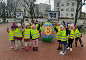 Dzieci przy kolorowym jajku, stojącym w centrum miasta.