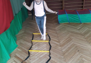 dziewczynka ćwicząca przejście przez "drabinkę"