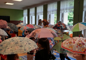 dzieci tańczące z parasolami