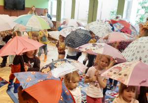 dzieci tańczące z parasolami