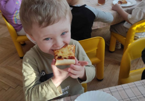 chłopiec jedzacy pizzę