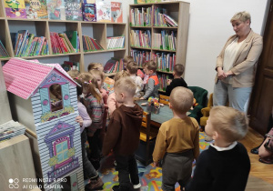 grupka dzieci wśród półek biblioteczbych