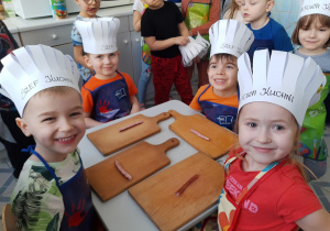 dzieci przygotowujące się do krojenia kiełbaski