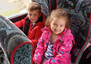 dziewczynka i chłopiec na siedzeniach autobusu