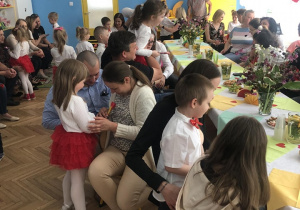 dzieci i rodzice siedzący przy stolikach