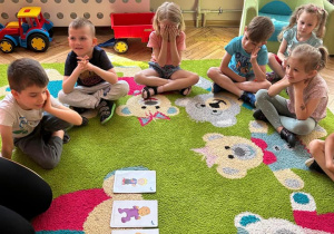 grupka dzieci siedząca na dywanie